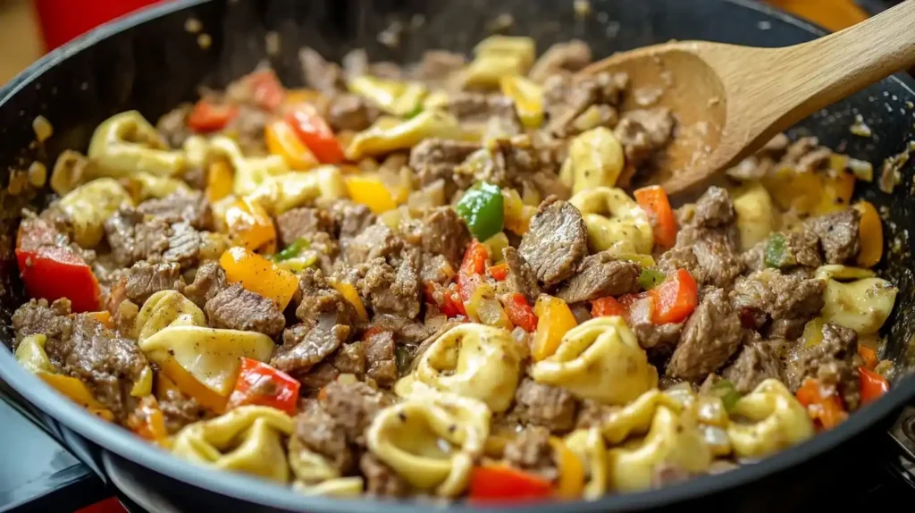 Philly Cheesesteak Tortellini: A Fusion Recipe to Savor 5 A skillet of Philly Cheesesteak Tortellini, with a creamy sauce coating every bite, filled with steak and vegetables.