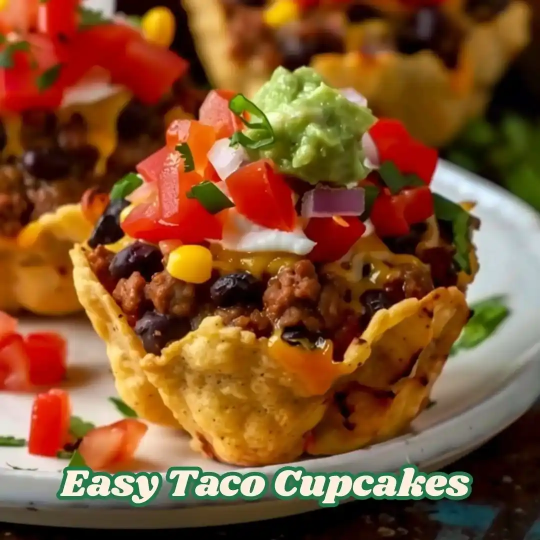 A close-up of crispy Easy Taco Cupcakes filled with seasoned ground beef, melted cheese, black beans, corn, diced tomatoes, and topped with guacamole and sour cream, served on a white plate.