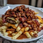 A plate of Maple Glazed Bacon Cheeseburger Poutine featuring crispy golden fries, melted cheese, a juicy beef patty, rich brown gravy, and a generous topping of caramelized maple-glazed bacon.